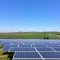 Panouri solare și turbine eoliene pe un fundal rural.