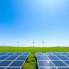 Panouri solare și turbine eoliene pe un câmp verde.